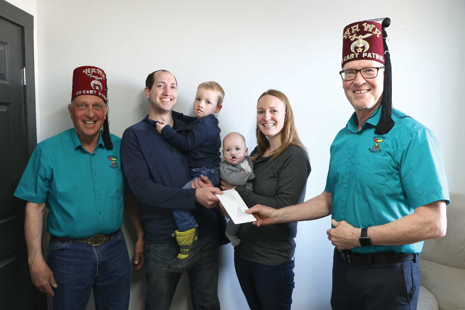 The Moosomin Shrine Club donated $3,000 to the McMullan family to help cover their travel expenses going to Toronto, as they go see a surgeon for the two boys. From left are Myles Fuchs, Shane, Calloway, Nicolette McMullan and Greg Gillespie.